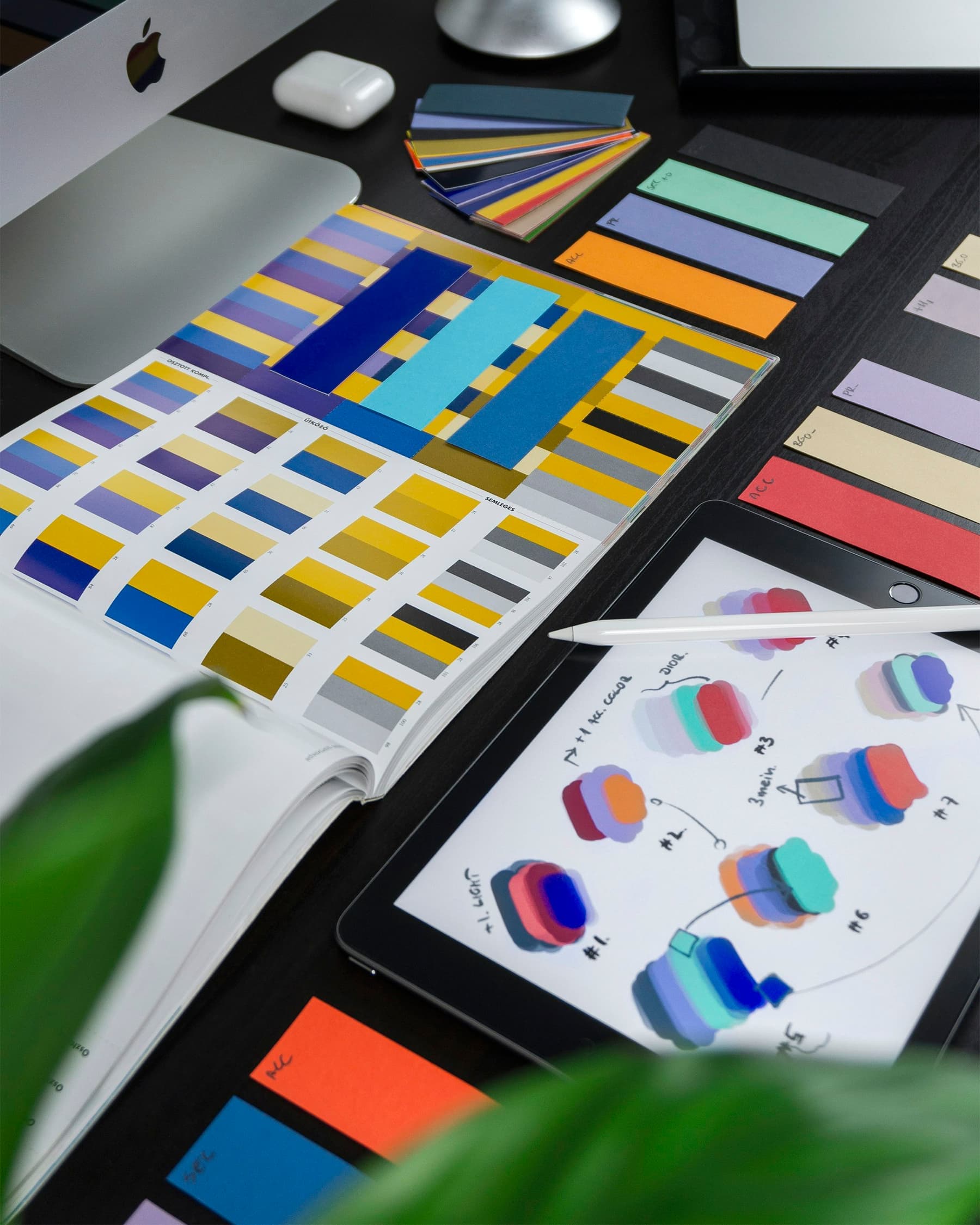Colour swatch cards and printed brand samples laid out on a table.